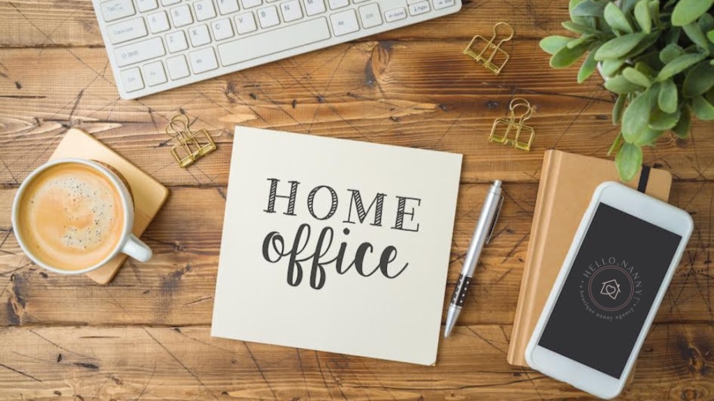 Home office setup with coffee, keyboard, smartphone, potted plant, notepad, and pen on a wooden desk.