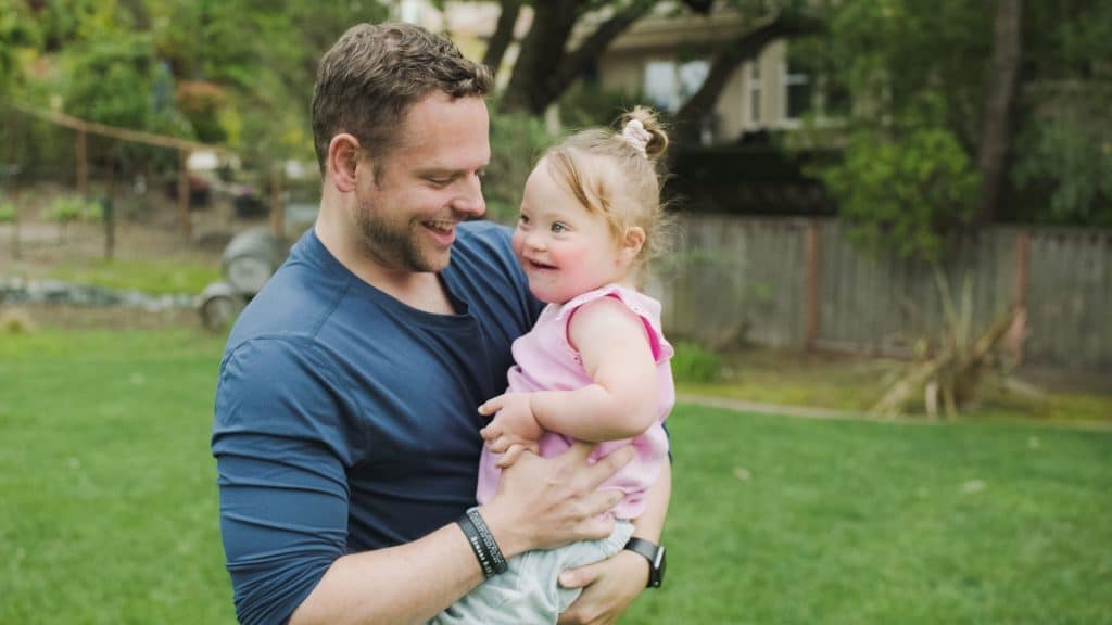 A devoted man cradles his baby, embodying the nurturing spirit of a homeschool nanny.